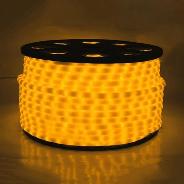 Крупный план круглого дюралайта: светодиоды внутри молочной ПВХ трубки, желтое свечение, видна структура шнура.